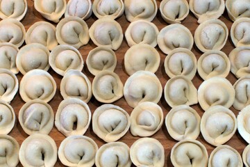 handmade frosted frozen dumplings on wooden board for home cooking