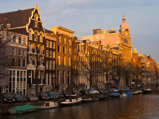 Netherlands, Amsterdam. Clock tower on historic building along the canal.