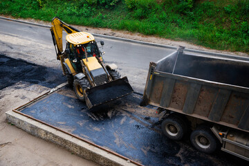 excavator and truck transport asphalt