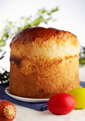 Easter sweet bread Orthodox kulich, paska, willow twigs. Easter Colorful eggs on gray wooden background. Easter Holidays breakfast. Easter Palm Sunday. Space for text.