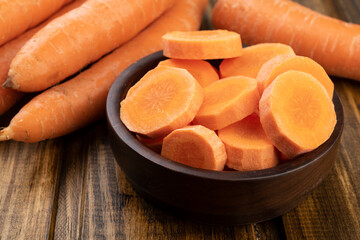 Carrots and slices on a plate over wooden table