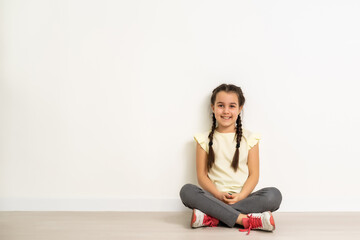 Fototapeta na wymiar lovely little girl sitting on the floor, isolated on white background