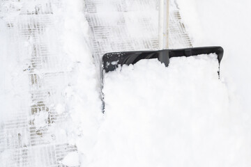 Snow cleaning with a large shovel in winter