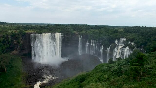 Distant view of Calandula waterfalls in Angola swallows flying around the camera mist all around the waterfall Aerial
