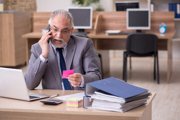 Old male employee working in the office