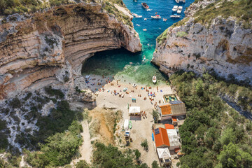 Aerial view of tourists sunbath swim at Stiniva cove beach of Adriatic sea on Vis Island in Croatia summer