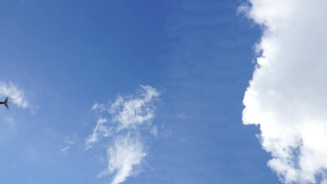 Low angle view of airplane on blue sky with white clouds