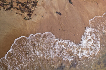 Sandy beach and waves. View from above.
