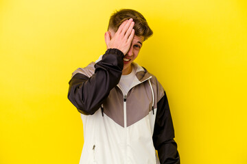 Fototapeta premium Young caucasian man isolated on yellow background forgetting something, slapping forehead with palm and closing eyes.