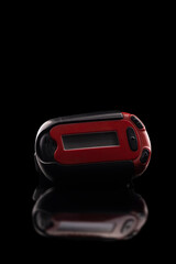 Retro red pager captured isolated on black background and reflective surface