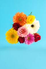 Creative arrangement with various spring flowers on a light blue background. Minimal nature concept.
