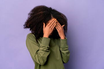 Young african american curly woman isolated on purple background afraid covering eyes with hands.