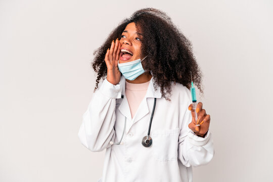 Young african american curly doctor woman holding a syringe shouting and holding palm near opened mouth. - Powered by Adobe