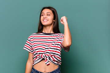 Young Indian woman isolated on blue background celebrating a victory, passion and enthusiasm, happy expression.