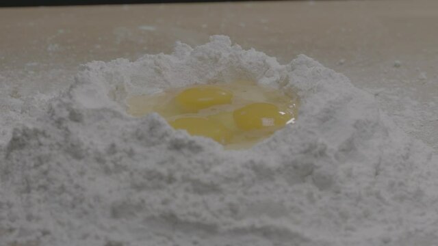 Dolly left to right of three eggs in a bowl of flour