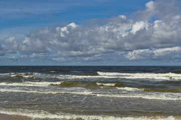 Beach during the day. Clouds and sea waves.
