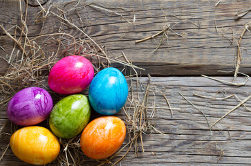 Colorful easter eggs on old wooden boards background