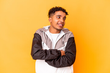 Young african american curly man isolated on purple smiling confident with crossed arms.