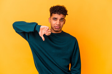 Young african american curly man isolated on purple showing a dislike gesture, thumbs down. Disagreement concept.