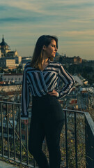 Joven mujer posando con camisa de rayas al atardecer