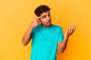 Young african american curly man isolated on purple showing a disappointment gesture with...