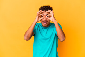 Young african american curly man isolated on purple excited keeping ok gesture on eye.