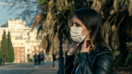 Chica joven con mascarilla de protección en el parque