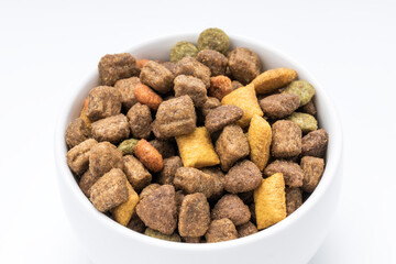 domestic animals dry food at white bowl isolated on white background. dried cat feed cut out. above view
