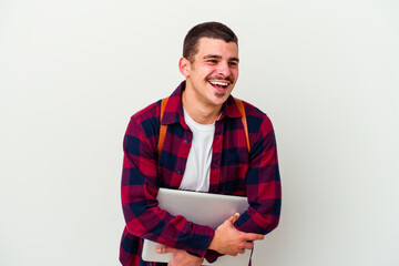 Young caucasian student man holding a laptop isolated on white background laughing and having fun.