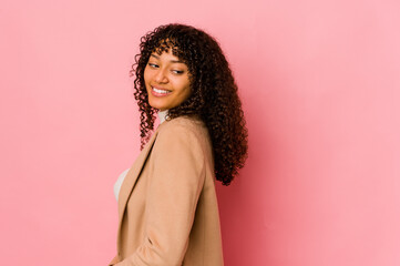 Young african american afro woman isolated looks aside smiling, cheerful and pleasant.