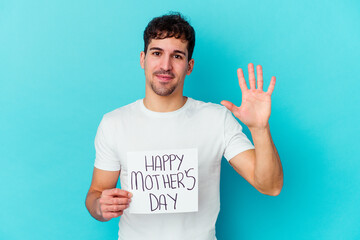 Young caucasian man holding a happy mothers day placard isolated smiling cheerful showing number five with fingers.