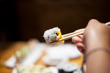 Eating fresh Sushi Point of View with Asian chopsticks in Chinese restaurant