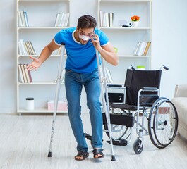 Young man recovering after surgery at home with crutches and a w