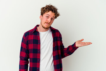 Young caucasian man isolated on white background doubting and shrugging shoulders in questioning...