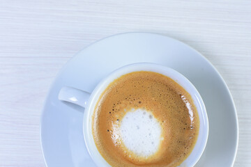 Cup of colombian coffee, decorated on white wooden background