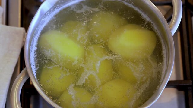 Boiling potatoes in cooking pot, close-up