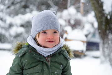 Fototapeta na wymiar Portrait of Down syndrome boy in a winter outfit.