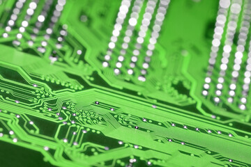 Green printed circuit board with selective focus and shiny pins bokeh background, diagonal...