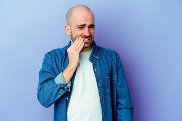 Young caucasian bald man isolated on purple background having a strong teeth pain, molar ache.