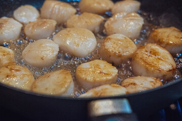 Scallops saute in a miso sauce in a saucepan