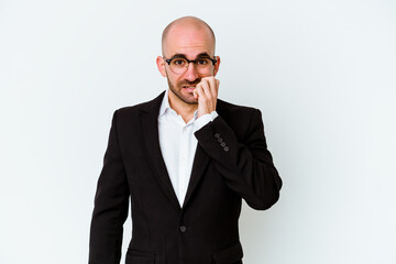 Young business caucasian bald man isolated on blue background biting fingernails, nervous and very anxious.