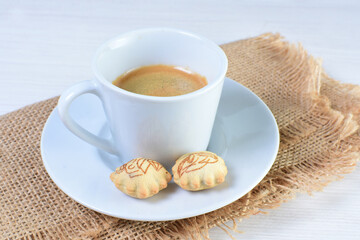 Cup of colombian coffee, decorated on white wooden background