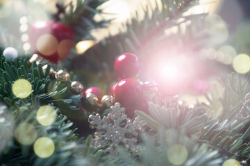 Festive elegant Christmas card. Blurry fir branches with holly berries, sparkles, bokeh and fairy...