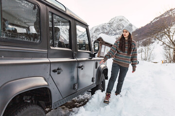 Adventurous young girl with her car in the snow