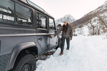 Adventurous young girl with her car in the snow