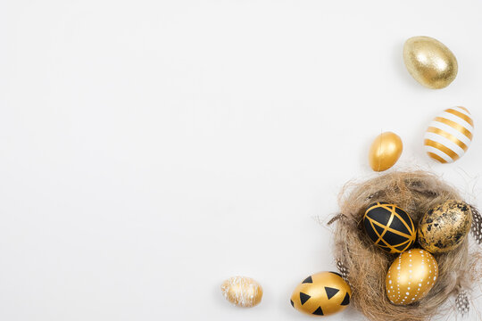 Easter golden blue decorated eggs in nest isolated on white background for web banner. Minimal easter concept. Happy Easter card with copy space for text. Top view, flatlay.