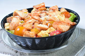 Rich very colorful vegetable salad, with croutons, strawberries, lettuce, Parmesan cheese and cherry tomato on white wooden background