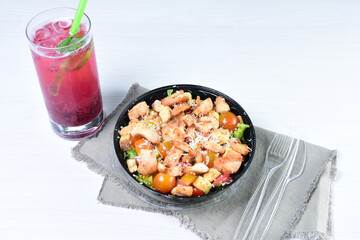 Rich very colorful vegetable salad, with croutons, strawberries, lettuce, Parmesan cheese and cherry tomato on white wooden background