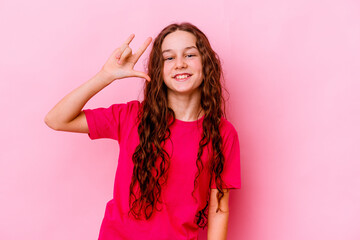 Fototapeta premium Little caucasian girl isolated on pink background showing a horns gesture as a revolution concept.