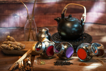 wooden table with different kinds of teas and spices